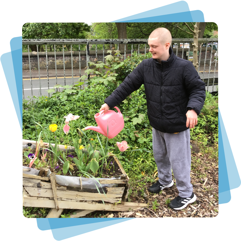 A boy water flowers with a pink watering can
